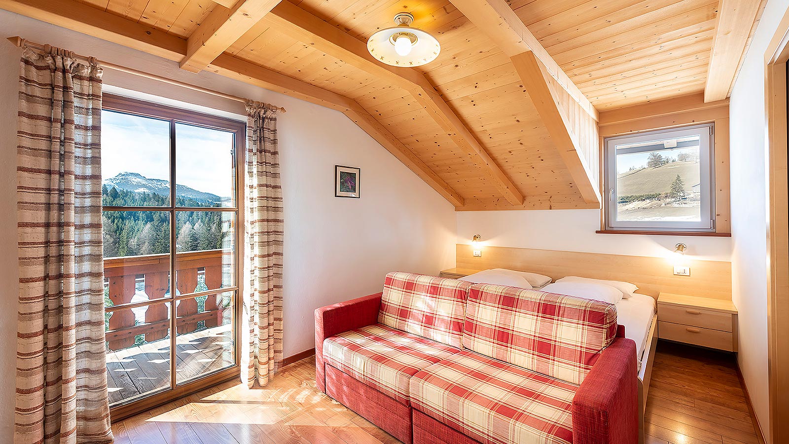 Il divano di una delle camere del Gasthof e dietro il panorama sulle Dolomiti
