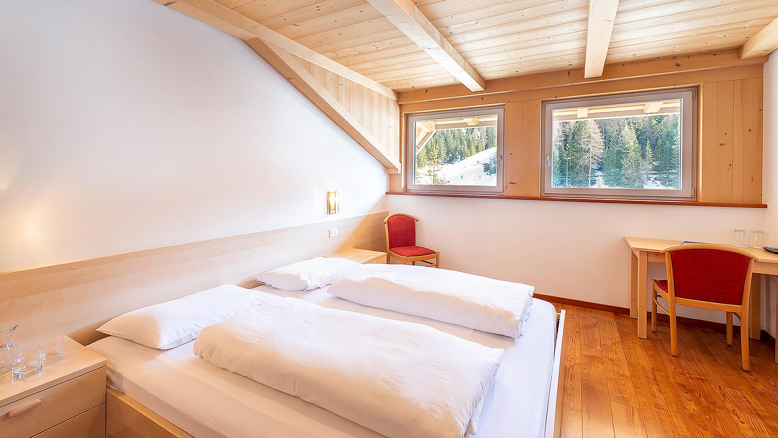 Dettaglio del letto di una delle camere della depandance della pensione a Obereggen