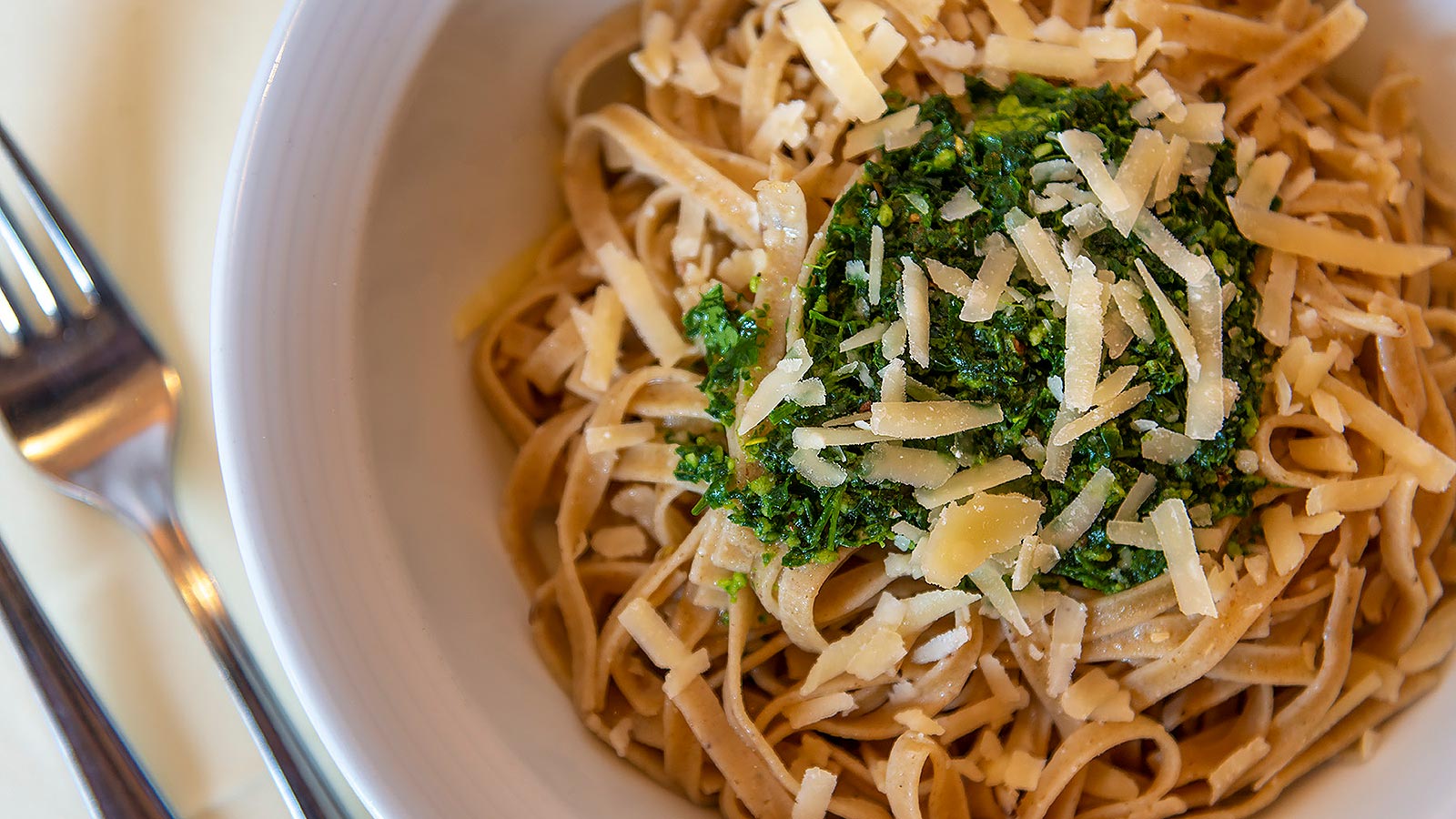 ein Teller Tagliatelle mit Pesto und Parmesankäse